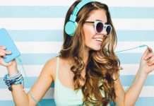 De 11 bedste websider, hvor du lovligt kan downloade gratis musik En ung kvinde med langt, bølget hår bærer et par lyseblå hovedtelefoner og holder en lyseblå enhed i den ene hånd. Hun har flere armbånd på håndleddet og står foran en baggrund med vandrette lyseblå og hvide striber.