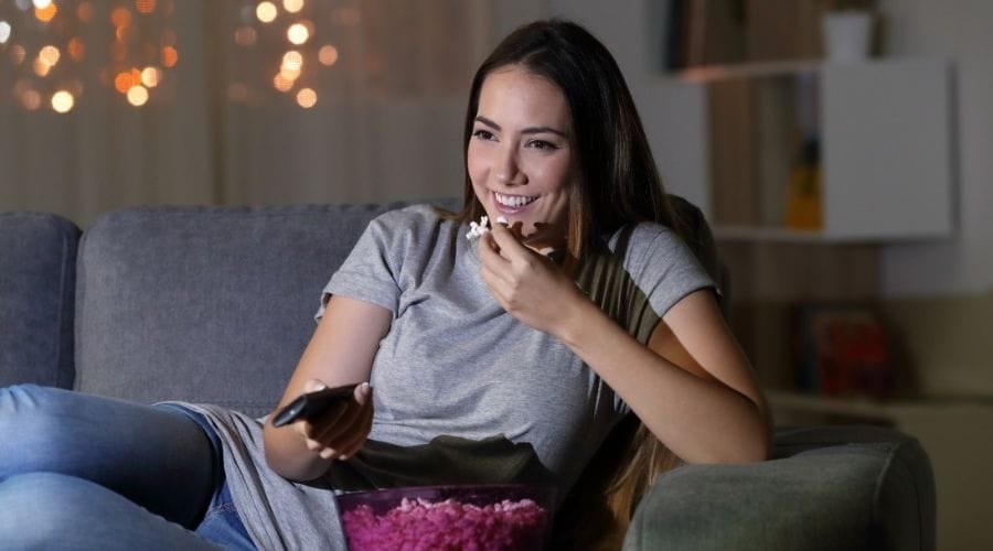 Girl watching TV with popcorn 