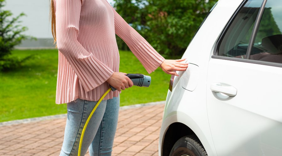 Pigen sætter elbilen til opladning