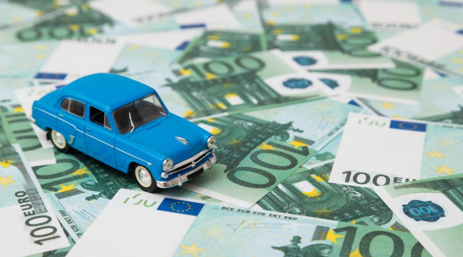 Fotocollage: En legetøjsbil står på eurosedler