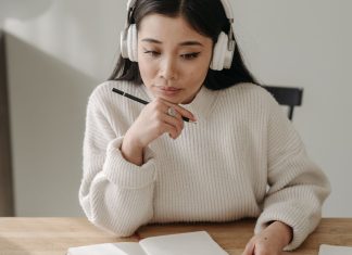 9 YouTube-kanaler, du kan streame, mens du studerer En pige med høretelefoner, der studerer ved sit skrivebord.