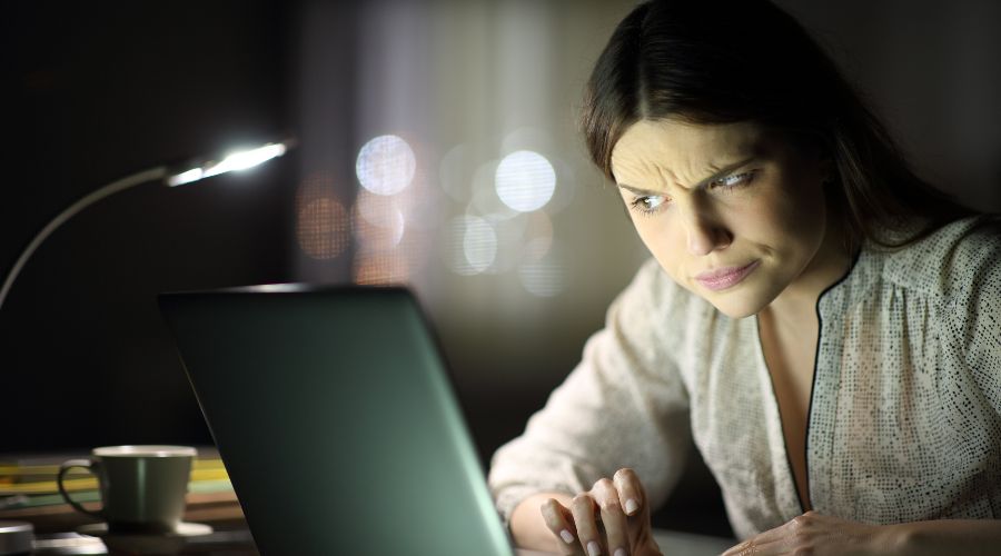 En overrasket pige foran en bærbar computer