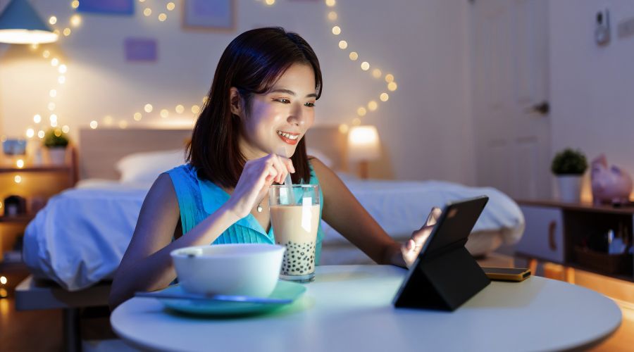 Pigen med tabletten ved spisebordet