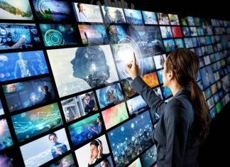 En pige foran en stor skærm, der består af mange små videoskærme