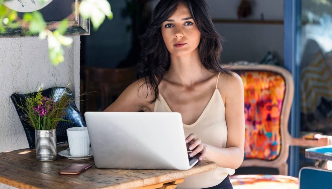 En pige ved et skrivebord foran en bærbar computer