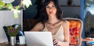 En pige ved et skrivebord foran en bærbar computer