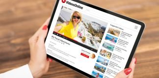 En tablet med en videoside på skærmen i kvinders hænder