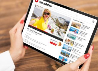 En tablet med en videoside på skærmen i kvinders hænder