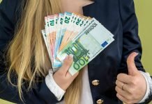 10 pålidelige måder at tjene penge på Amazon En pige holder en vifte med eurosedler.