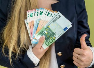 En pige holder en vifte med eurosedler.