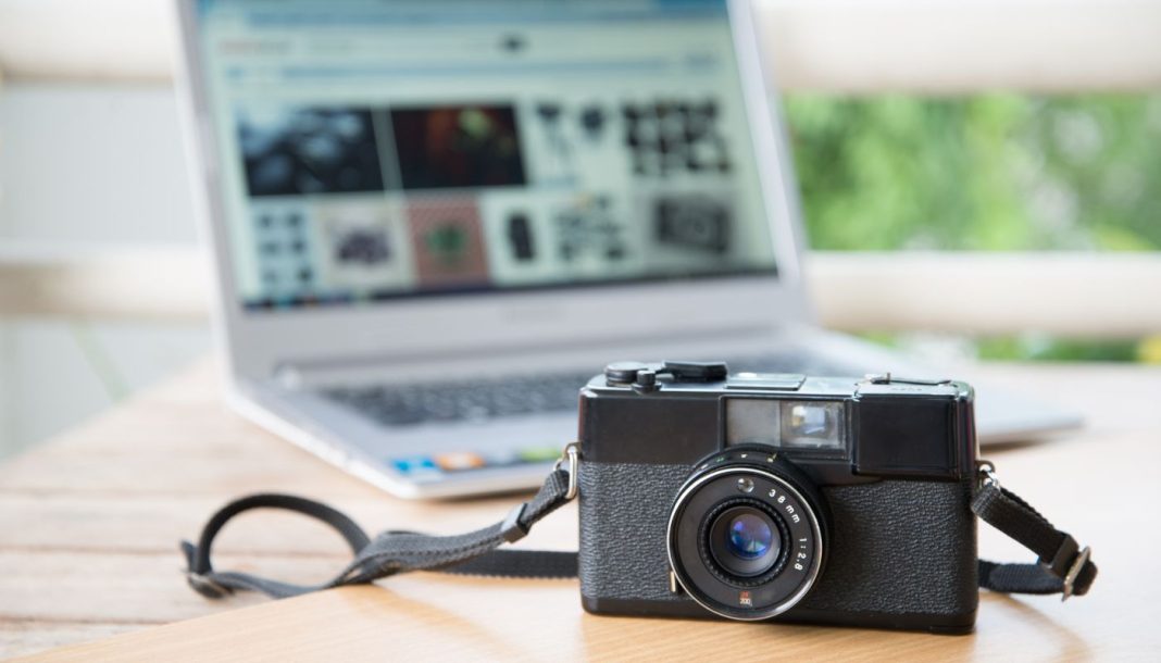 Kameraet ligger på et bord med en bærbar computer åben i baggrunden
