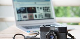 Kameraet ligger på et bord med en bærbar computer åben i baggrunden