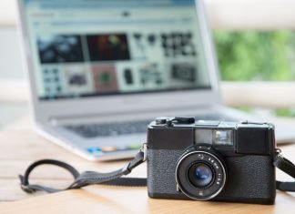 Kameraet ligger på et bord med en bærbar computer åben i baggrunden