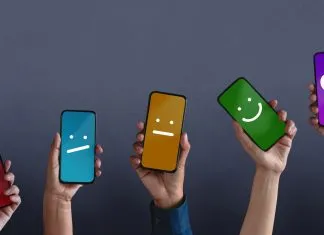 Fem hænder rakte op med smartphones, hvis skærme viser forskellige smileys på forskellige farvede baggrunde