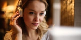 En pige med hovedtelefoner sidder foran en skærm