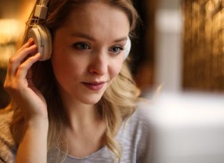 En pige med hovedtelefoner sidder foran en skærm