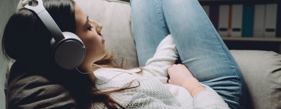 En pige med hovedtelefoner sidder i en stol