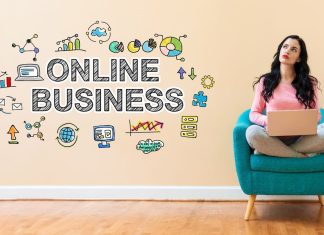 En pige sidder i en stol med en bærbar computer, og ved siden af på væggen er der et skilt: online business