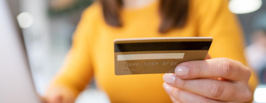 Pigen holder et kreditkort i hånden