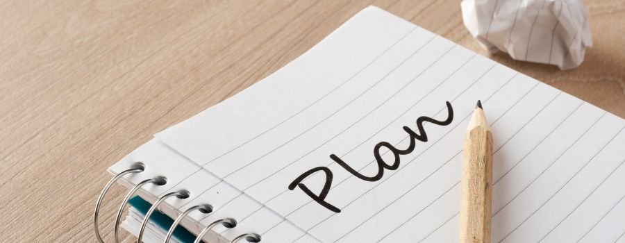 Sådan starter du en sidebeskæftigelse hjemmefra: En guide til begyndere 3 På bordet ligger en notesbog, hvor der står "Plan".