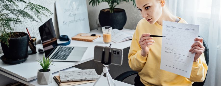 Sådan starter du en sidebeskæftigelse hjemmefra: En guide til begyndere 1 Pigen streamer og viser et dokument i sit telefonkamera