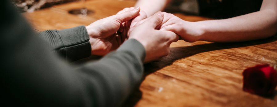 Kvindernes hænder i mændenes hænder på bordet