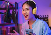 8 gratis apps, du kan bruge til at lytte til dine yndlingspodcasts En pige iført høretelefoner og med en telefon i hånden foran en mikrofon med åben mund