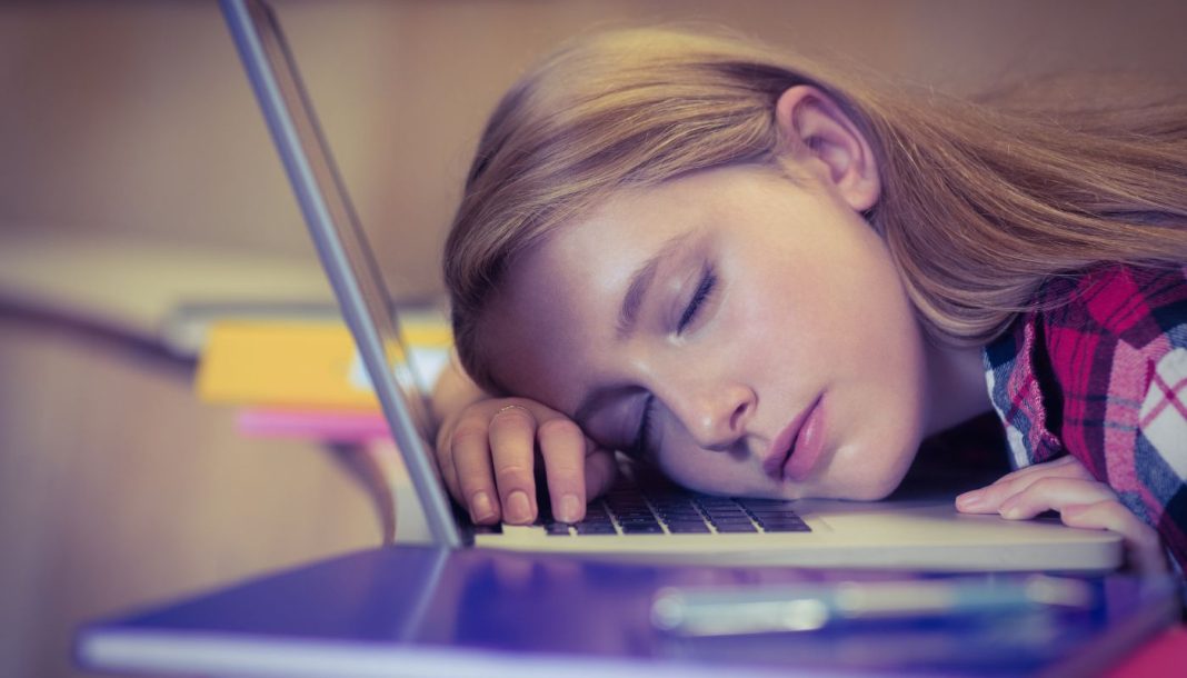 En pige sover på et laptop-tastatur.