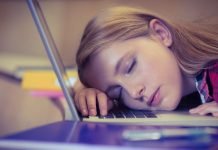 En pige sover på et laptop-tastatur.