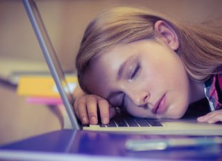 En pige sover på et laptop-tastatur.