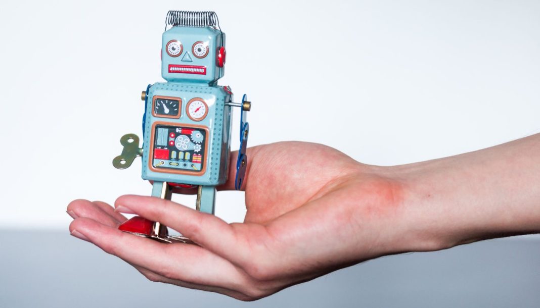 En lille legetøjsrobot i en kvindes håndflade