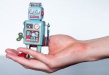 En lille legetøjsrobot i en kvindes håndflade