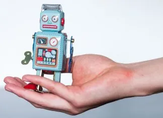 Hvad er Crypto Trading Bots, og hvordan fungerer de? En lille legetøjsrobot i en kvindes håndflade