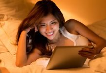 De 14 bedste sider til at se film gratis Asiatisk pige med en tablet i hænderne ligger i sengen