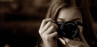 En pige med et Sony-kamera kigger i søgeren