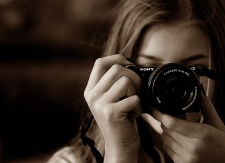 En pige med et Sony-kamera kigger i søgeren