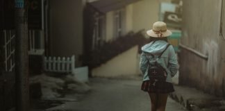 En pige med en sort rygsæk bag sig går ned ad en gade i byen.