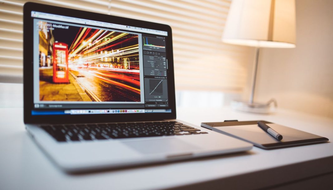 Apple MacBook Pro laptop på bordet med Lightroom åben på skærmen.