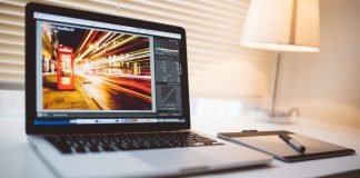 Apple MacBook Pro laptop på bordet med Lightroom åben på skærmen.