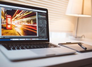 De 10 bedste Lightroom-tutorials på YouTube Apple MacBook Pro laptop på bordet med Lightroom åben på skærmen.