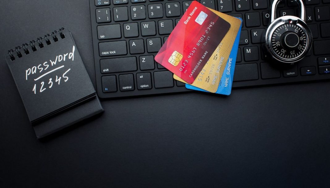 En notesbog med adgangskoden "12345", to kreditkort, der ligger på et tastatur, og en hængelås.