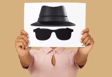 Hvad sker der egentlig, når man surfer i inkognito-tilstand? En person holder et ark med en tegning af en hat og solbriller, der symboliserer inkognito-tilstand