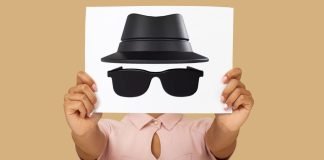 En person holder et ark med en tegning af en hat og solbriller, der symboliserer inkognito-tilstand