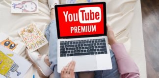 Kvinde med en bærbar computer på skødet, hvor YouTube Premium-logoet vises på skærmen.