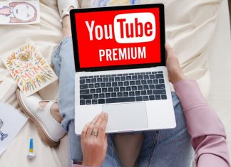 Kvinde med en bærbar computer på skødet, hvor YouTube Premium-logoet vises på skærmen.