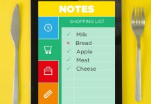 En tablet med en indkøbsliste. Listen indeholder mælk, brød, æble, kød og ost. Nogle varer er afkrydset.