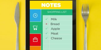 En tablet med en indkøbsliste. Listen indeholder mælk, brød, æble, kød og ost. Nogle varer er afkrydset.