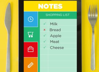 En tablet med en indkøbsliste. Listen indeholder mælk, brød, æble, kød og ost. Nogle varer er afkrydset.
