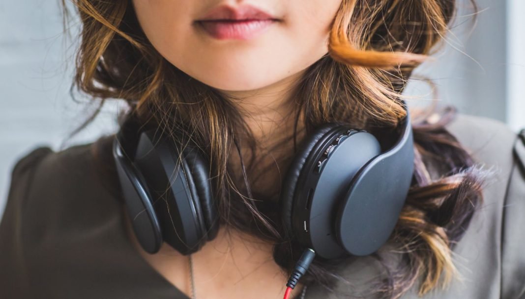 musik En pige med sorte hovedtelefoner rundt om halsen.