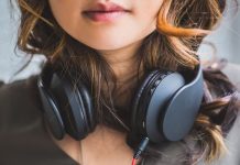 En pige med sorte hovedtelefoner rundt om halsen.